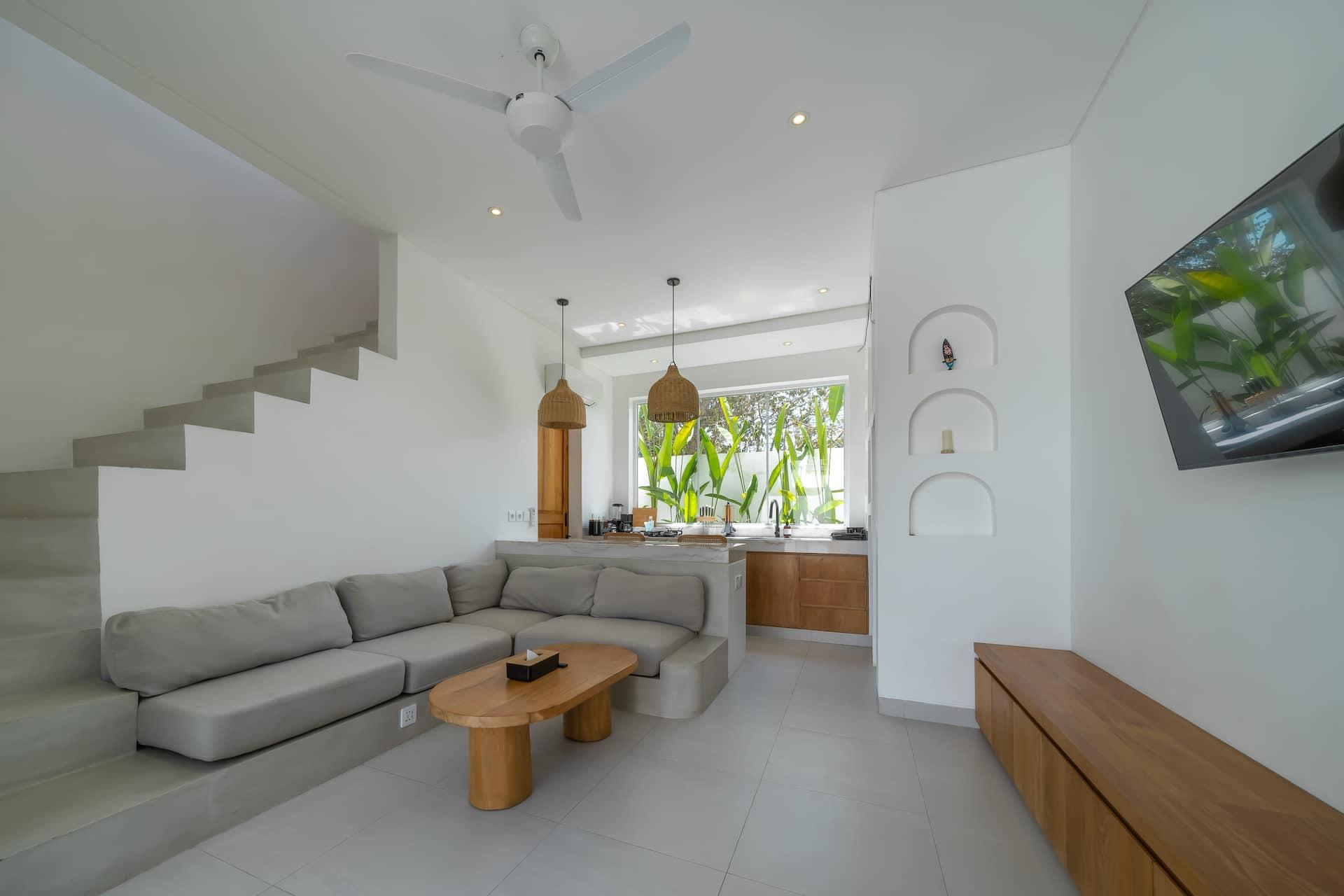 The living room at Las Casas 5 seen from the staircase, with arched recesses in the white wall
