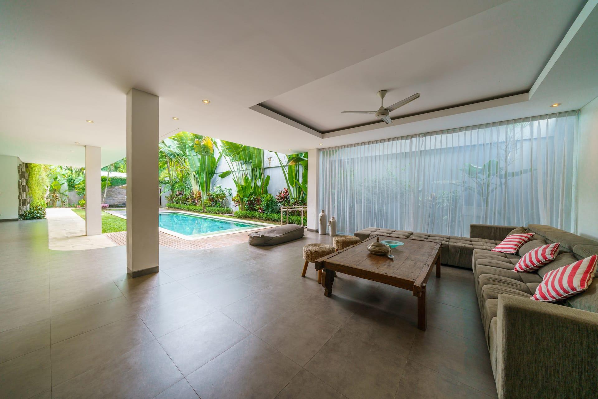 Living floor at Villa Paloma open to the garden, the pool a few steps from the sofas