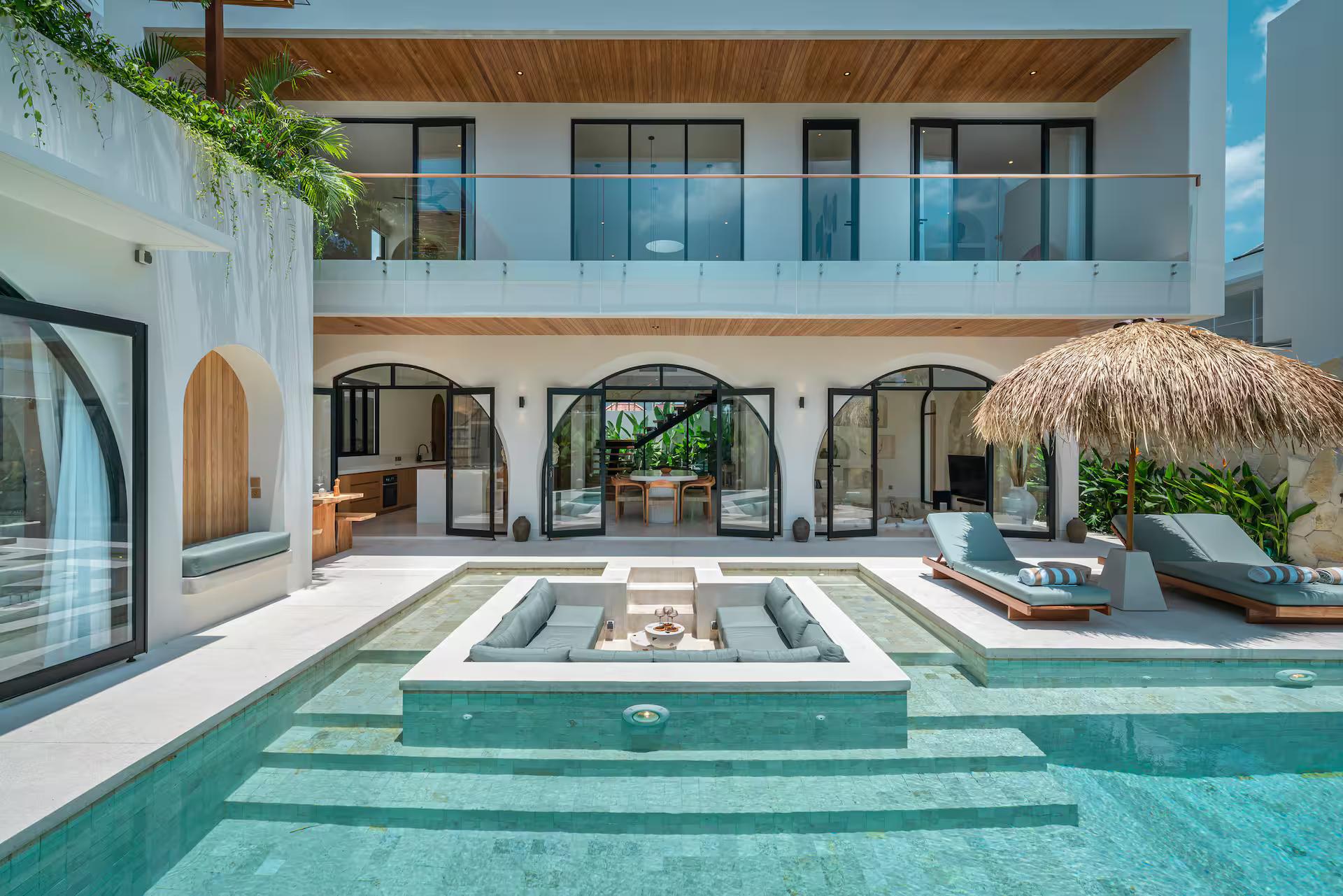 The sunken seating pit in the middle of the pool at Villa Bimini, arches on both floors behind