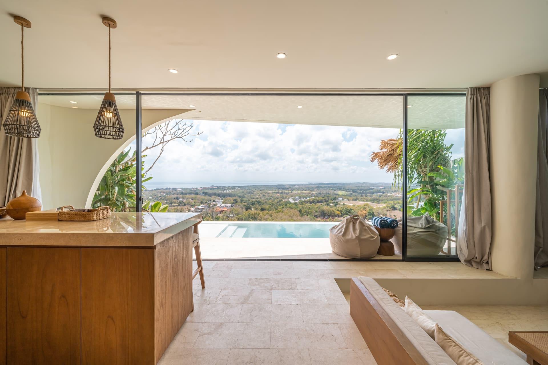Kitchen island looking through open glass walls to the pool and the view towards the ocean