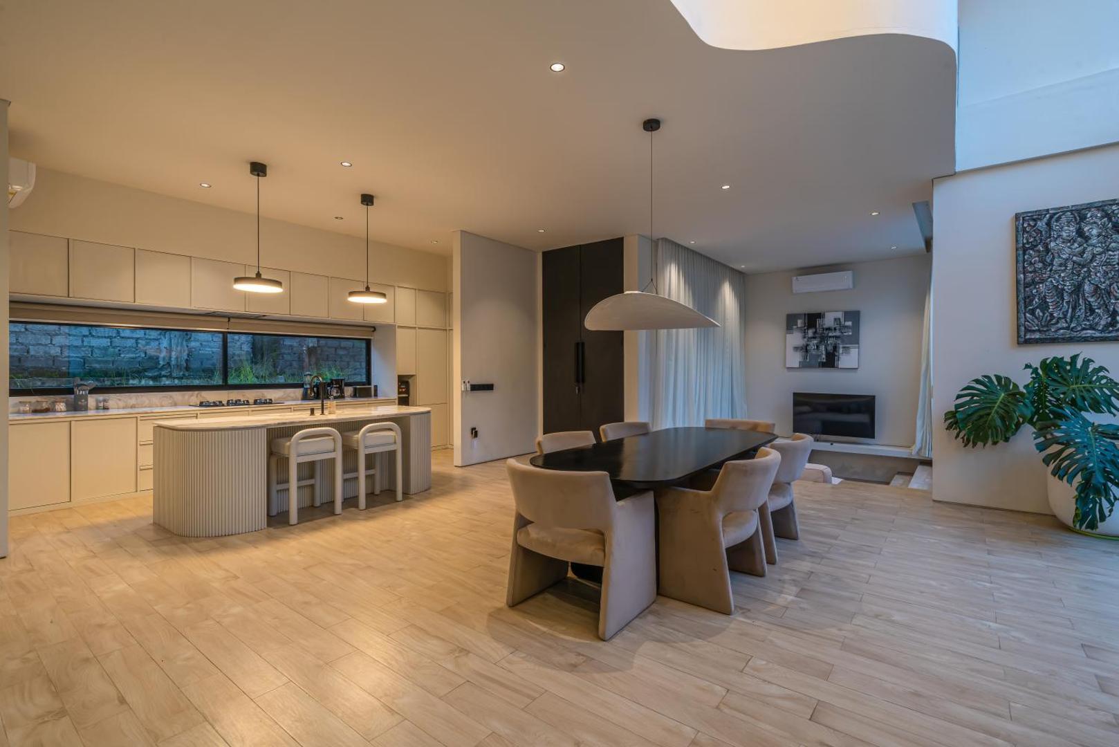 Marble kitchen island, oval dining table and the living room at Villa Kiyoji in one volume