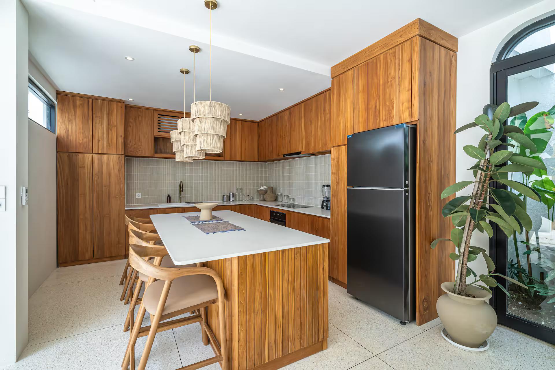 Timber kitchen with a stone-topped island and cane bar stools at Bellavista Amici