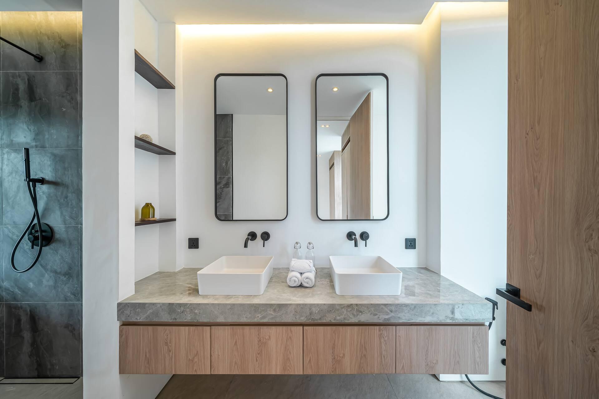 Ensuite with twin vessel basins, stone-clad walls and a walk-in rain shower