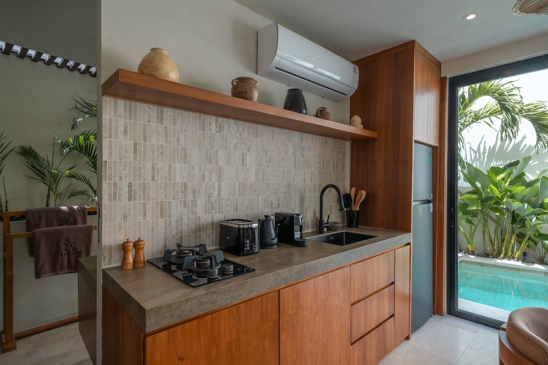 Kitchen at Villa Elementa with stone counters, a mosaic splashback and open timber shelving