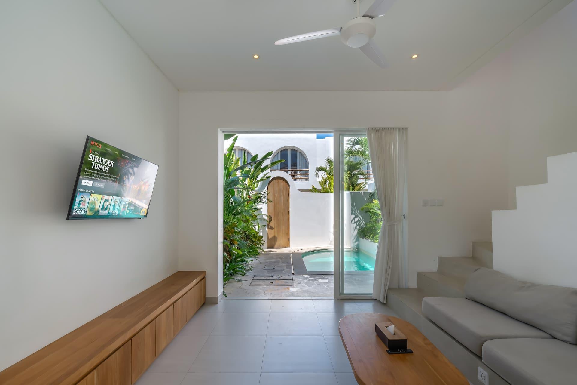 Glazed doors lead straight from the living room out to the pool courtyard and the arched gate