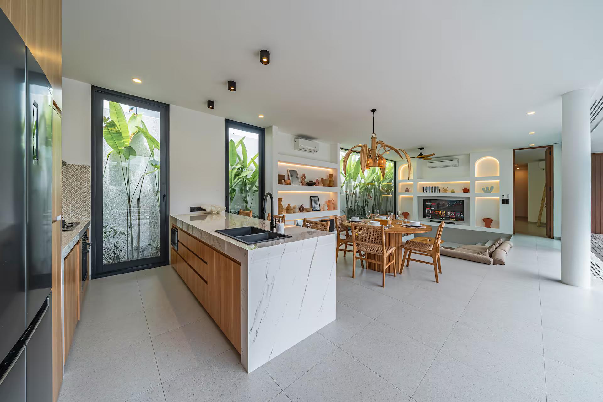 White stone waterfall island and timber cabinetry in one of the three kitchens at Uluwatu Tropical Estate