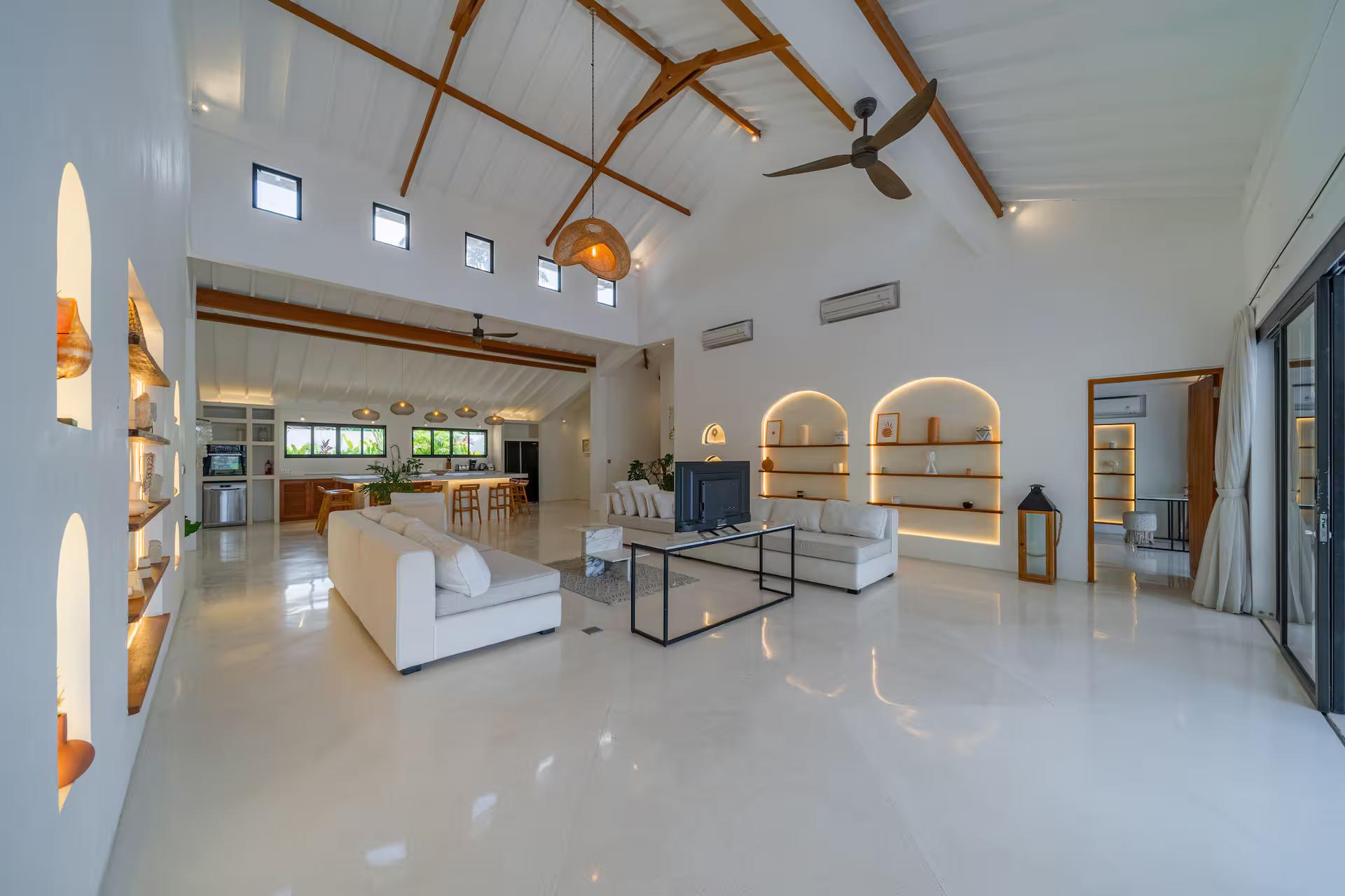 Living and dining running together beneath exposed timber trusses at Villa Wellness Bisous
