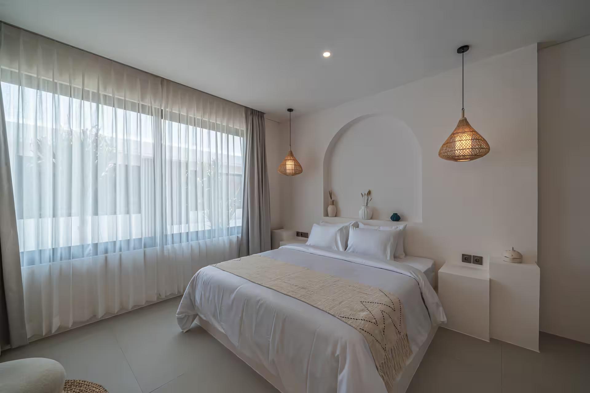 Second king bedroom at Nova Oasis 3, curtain wall along one side and a plaster ledge by the bed