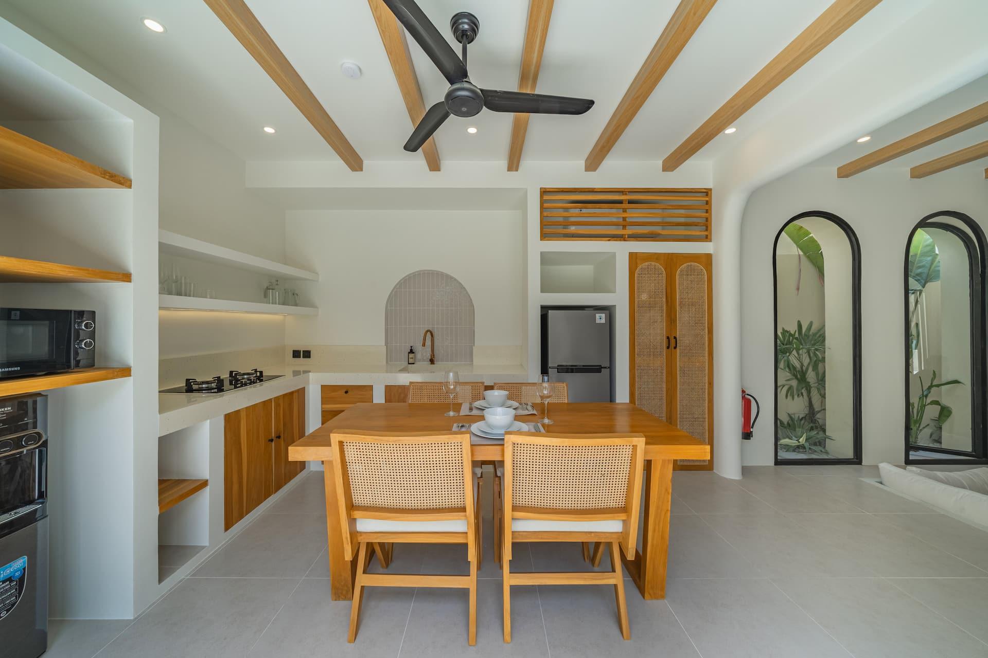 Kitchen with timber cabinetry, a tiled arched splashback and dining table for four