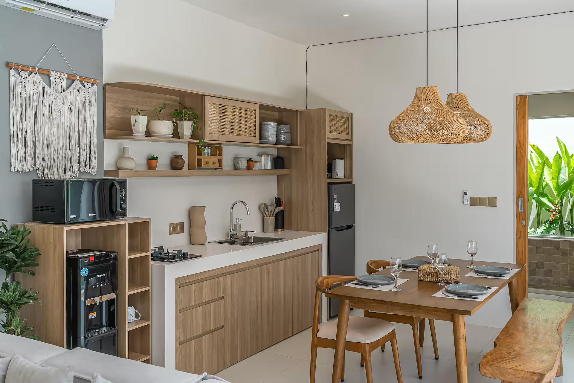 Kitchen in light timber with open shelves and a macrame hanging, beside the dining table