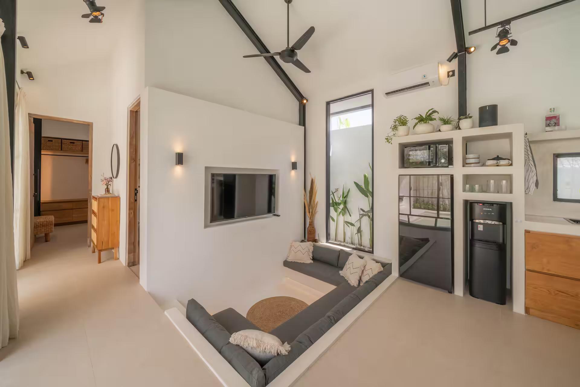 Living room with the sunken bench, screen and open kitchen counter beyond