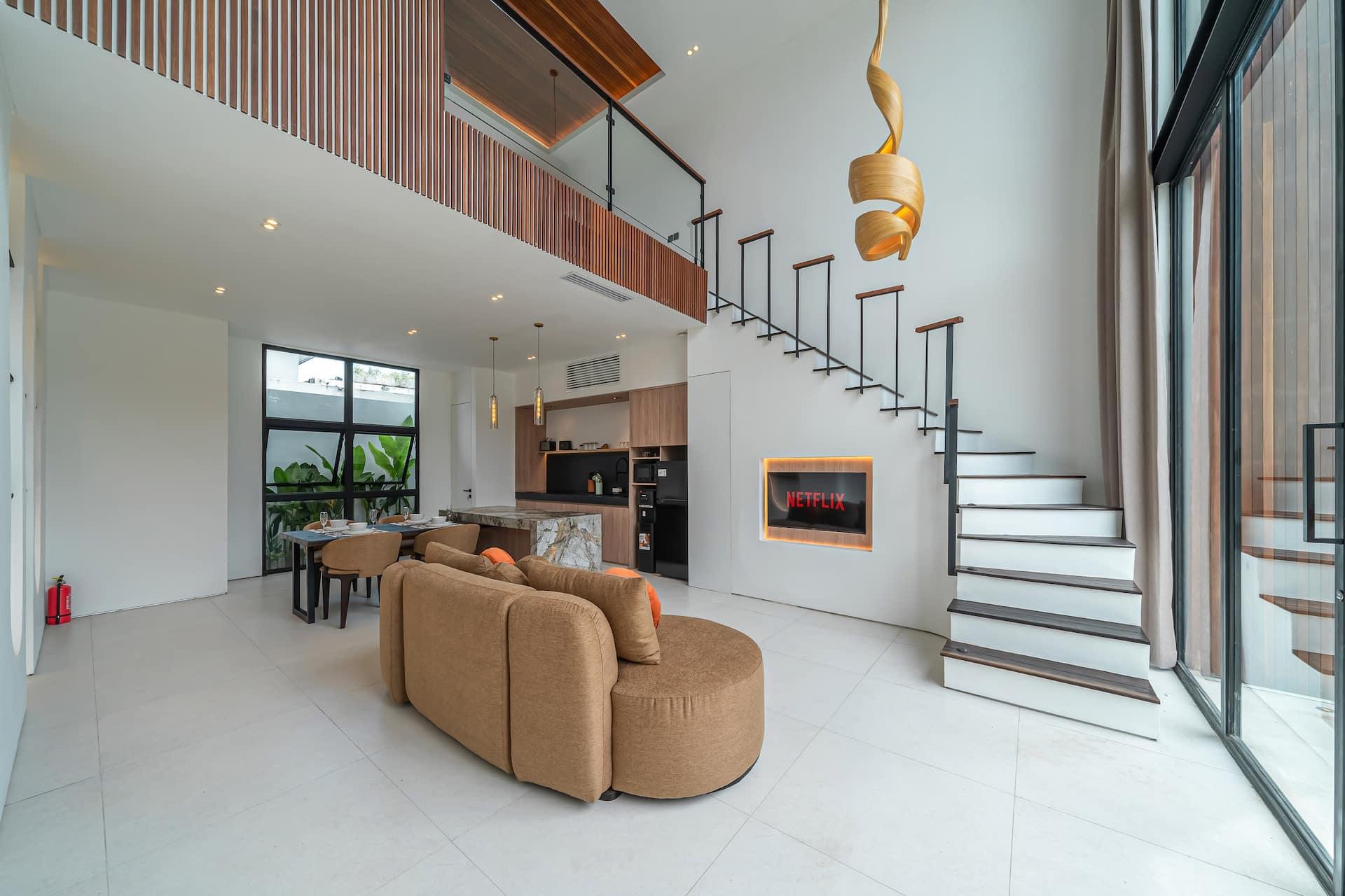 Living, dining and kitchen flowing together beneath the mezzanine at Fire Villa Berawa