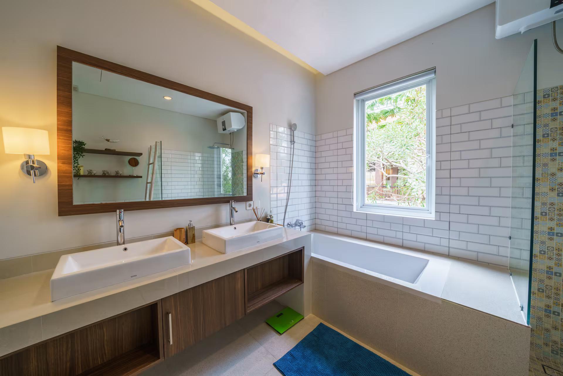 Bathroom with twin basins on a timber vanity, a bath and white metro tile